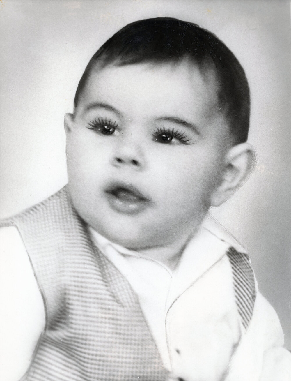 A  baby in a vest