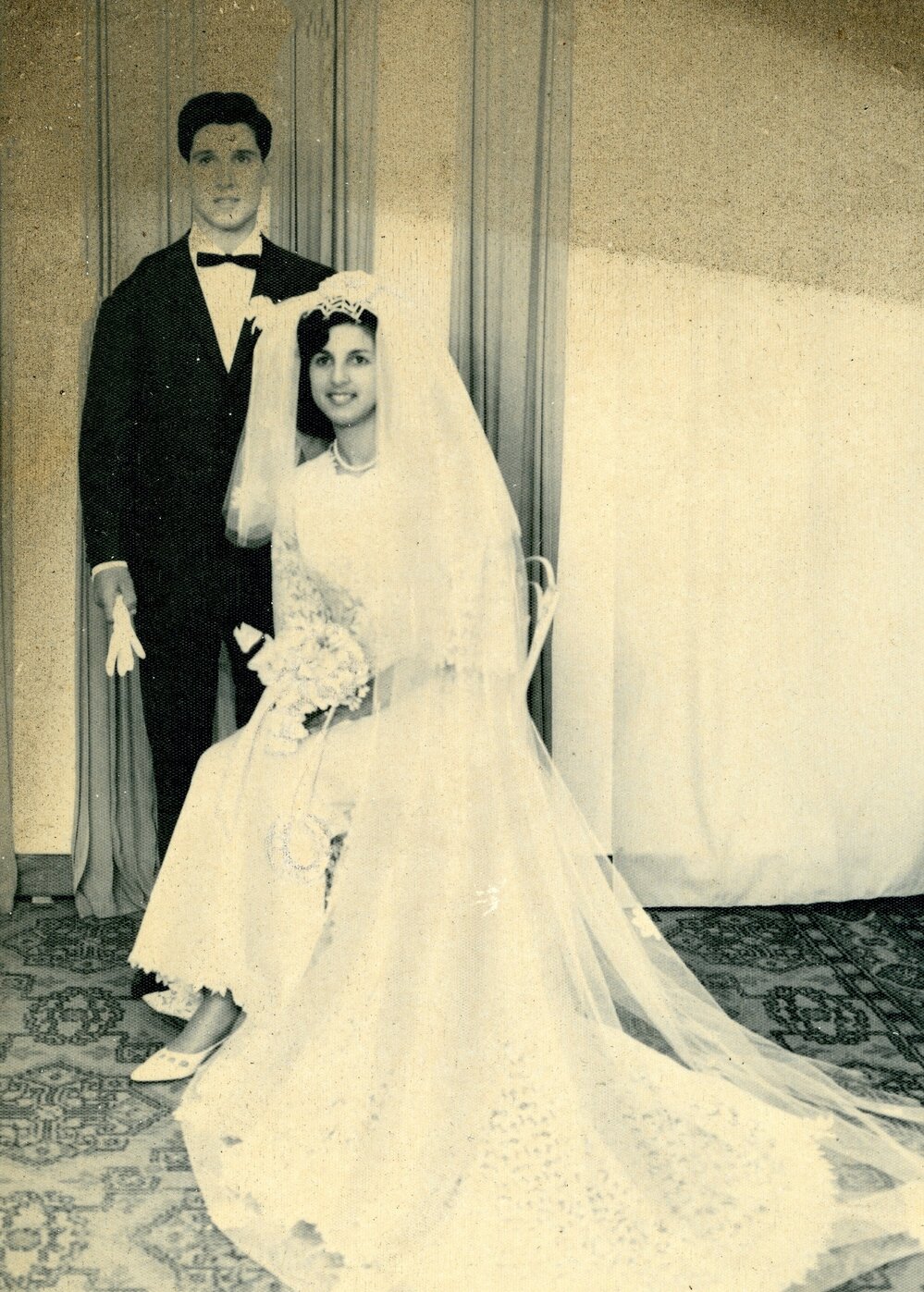 A seated bride and her groom
