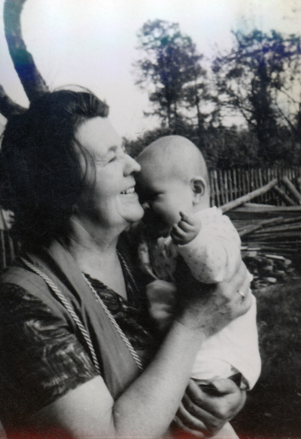 A smiling woman holding a baby 