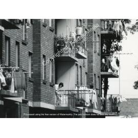 Resident on a balcony of a unit in Cabramatta