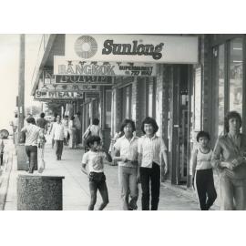 Pedestrians walking past Asian stores in Cabramatta