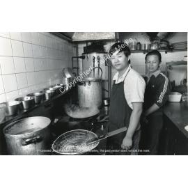 Workers cooking inside a restaurant's kitchen in Cabramatta