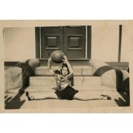 Shirley Kingsford McLeod in a split sit pose outside the Smithfield Literary Institute, Smithfield NSW, c. 1943