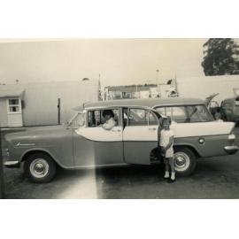 A young man and a small boy near a car, Cabramatta Hostel, Cabramatta NSW