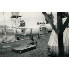 A boy filling a pool with water, Cabramatta Migrant Hostel, Cabramatta NSW