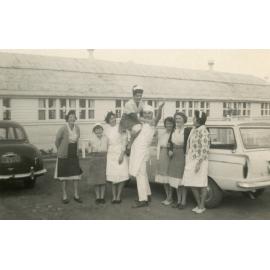 A group of people standing near a car, Cabramatta Migrant Hostel, Cabramatta NSW, 1960s