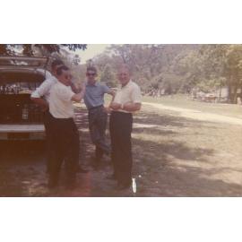Four men standing behind a car, Cabramatta Migrant Hostel, Cabramatta NSW