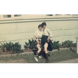 Two women in kilts showing their britches, Cabramatta Migrant Hostel, Cabramatta NSW