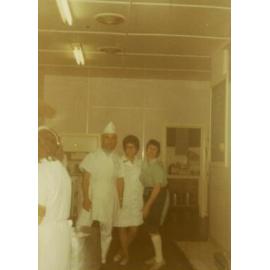 Three people standing in the kitchen, Cabramatta Migrant Hostel, Cabramatta, NSW.