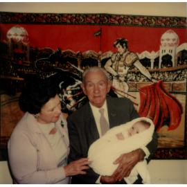 An older man holding a baby