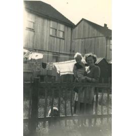 Woman with child standing near a fence