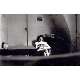 Mrs Robinson seated inside one of the huts, Cabramatta Migrant Hostel, Cabramatta NSW